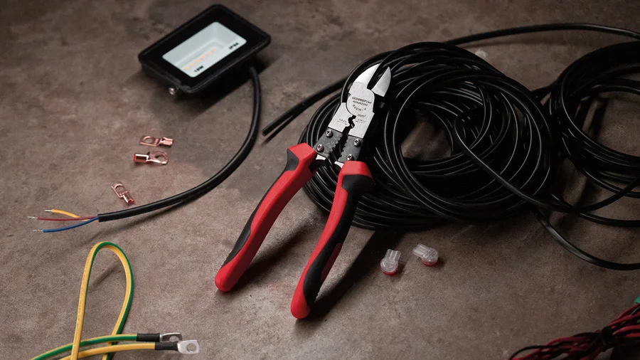 Multifunktionszange von GEDORE red auf dem Boden einer Baustelle angelehnt an einem Kabel