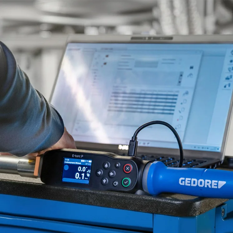 Elektronischer Drehmomentschlüssel von GEDORE auf einem Werkstattwagen vor einem Laptop