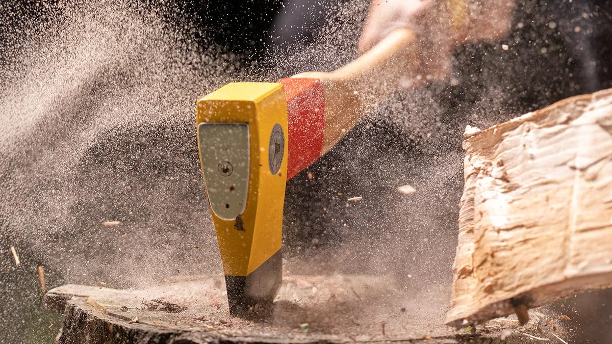 OCHSENKOPF Axt beim Spalten eines Baumstamms, Axtkopf und Holz im Detail sichtbar
