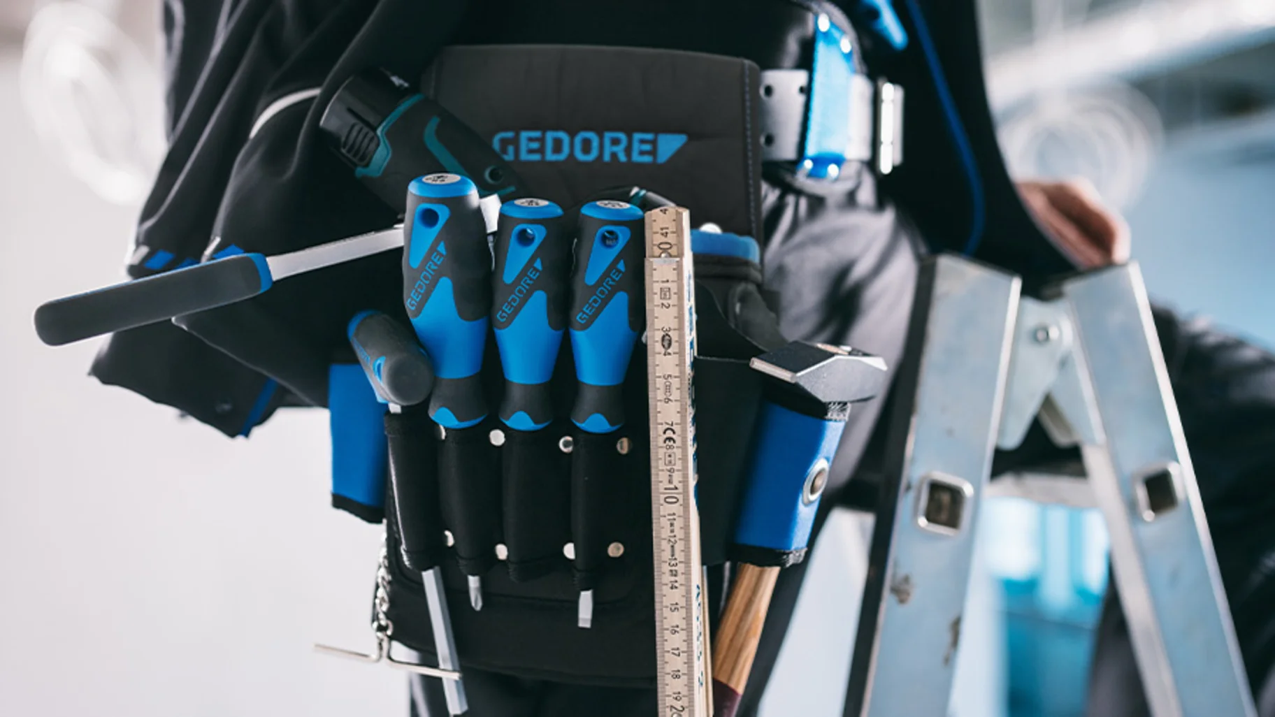 Handwerker auf einer Leiter trägt Werkzeuggürtel mit Werkzeughaltern von GEDORE