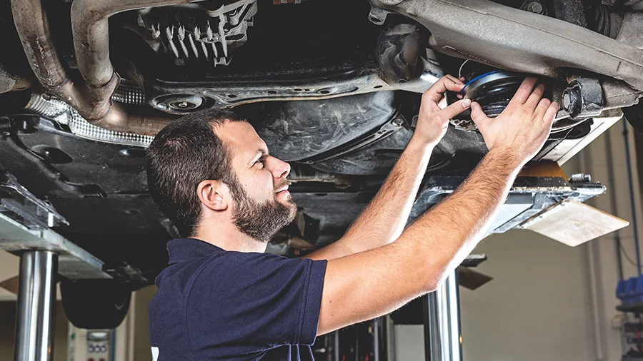 Kfz-Mechatroniker beim Einbau eines Federbeins