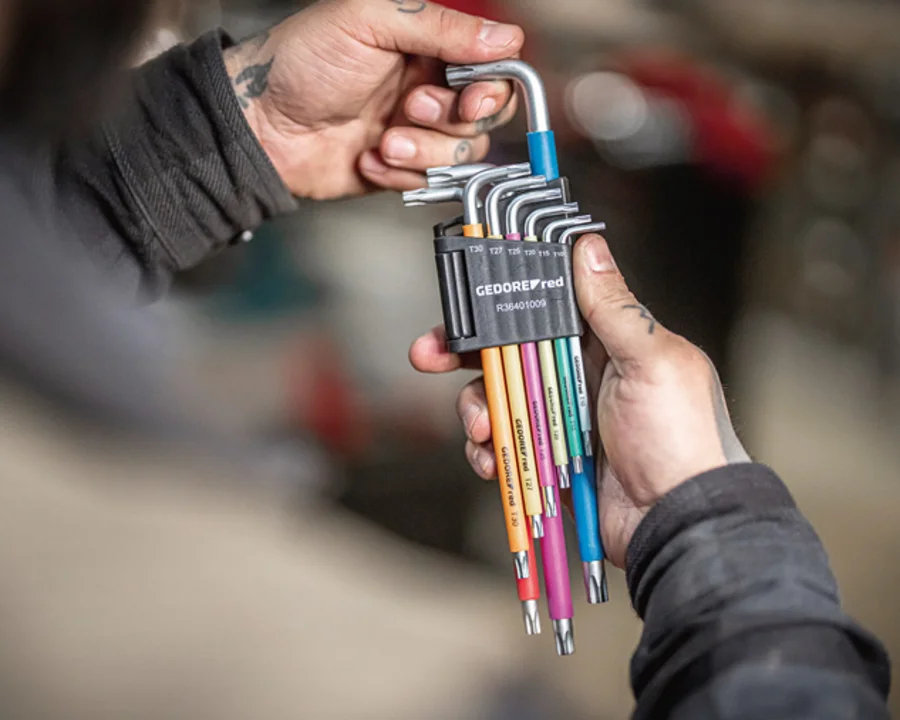 Handwerker nimmt einen Winkelschraubendreher aus einem Winkelschraubendreher-Satz heraus.